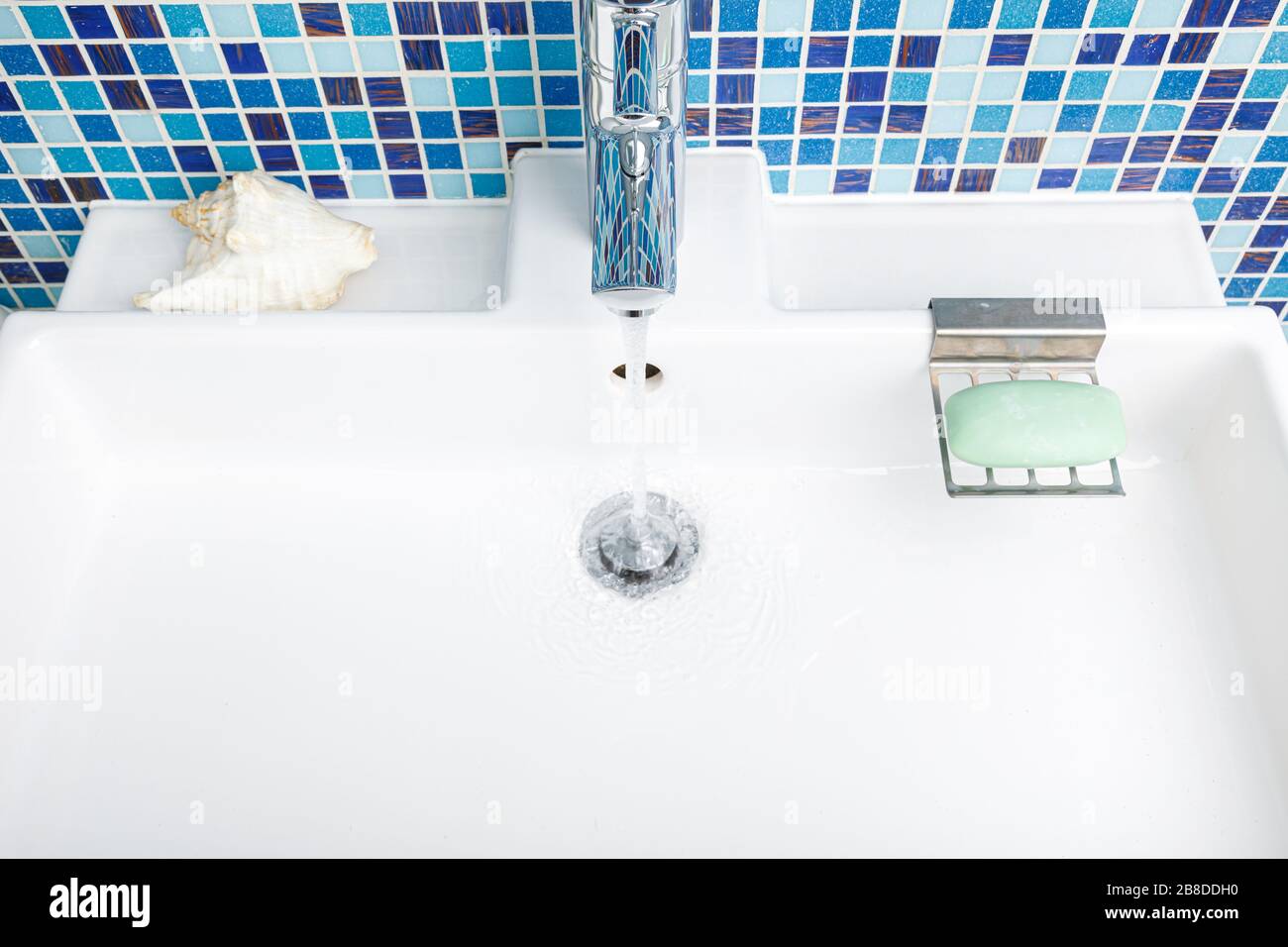 Bathroom sink tap with running water - wasting water concept Stock Photo