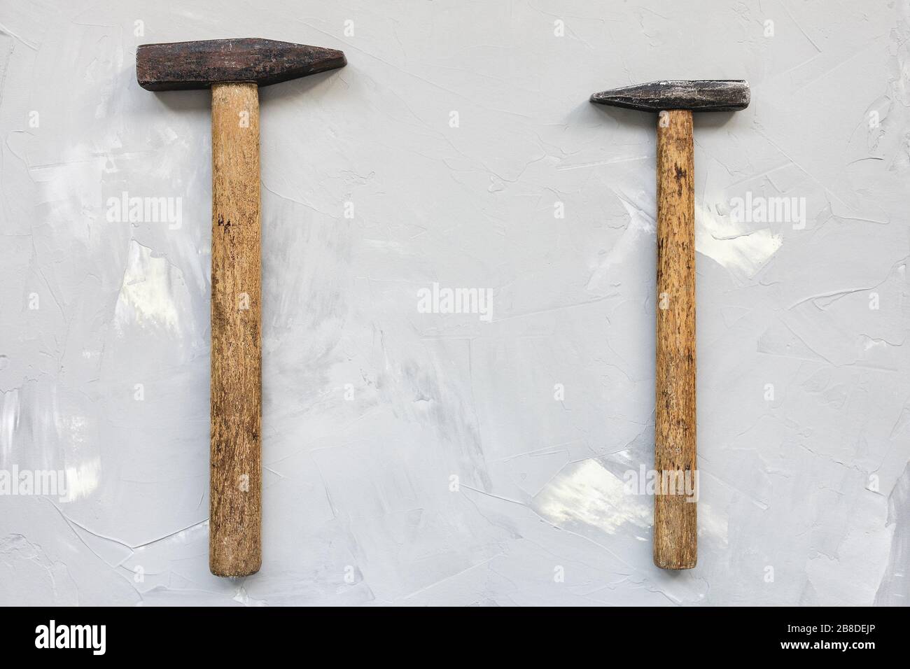 Two old rusty hammers on gray background, carpentry concept, copy space Stock Photo
