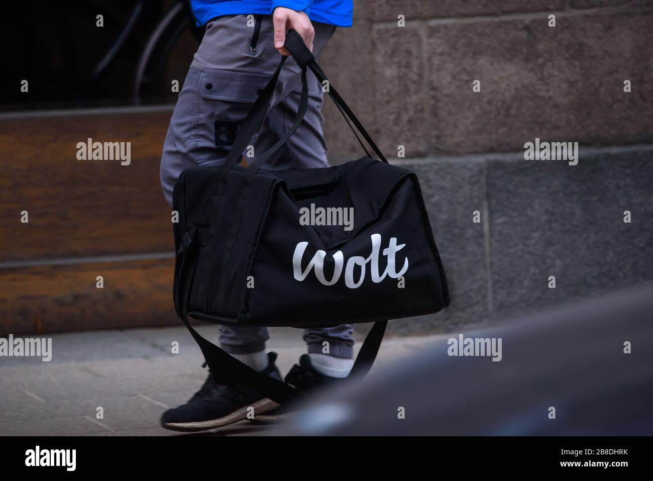 RIGA, LATVIA. 25th November 2019. Wolt company food delivery worker walks with food bag in Riga city. Wolt is Finnish technology company that is known for its food-delivery platform. Stock Photo