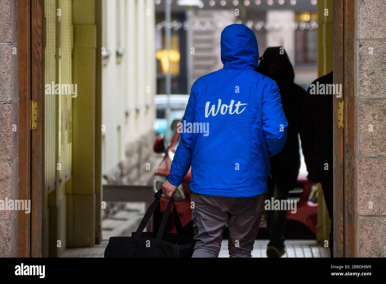 RIGA, LATVIA. 25th November 2019. Wolt company food delivery worker walks with food bag in Riga city. Wolt is Finnish technology company that is known for its food-delivery platform. Stock Photo