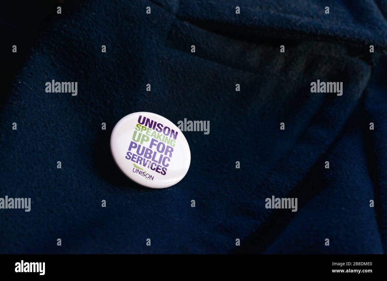 A 'Speaking up for Public Services' UNISON badge attached on a blue jacket Stock Photo