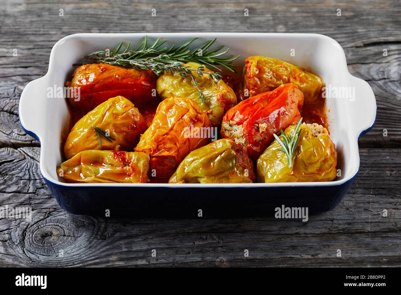 Instant pot sweet peppers stuffed with rice and minced meat: beef and pork with tomato sauce, rosemary, and thyme, cajun spices on a baking dish, on a Stock Photo