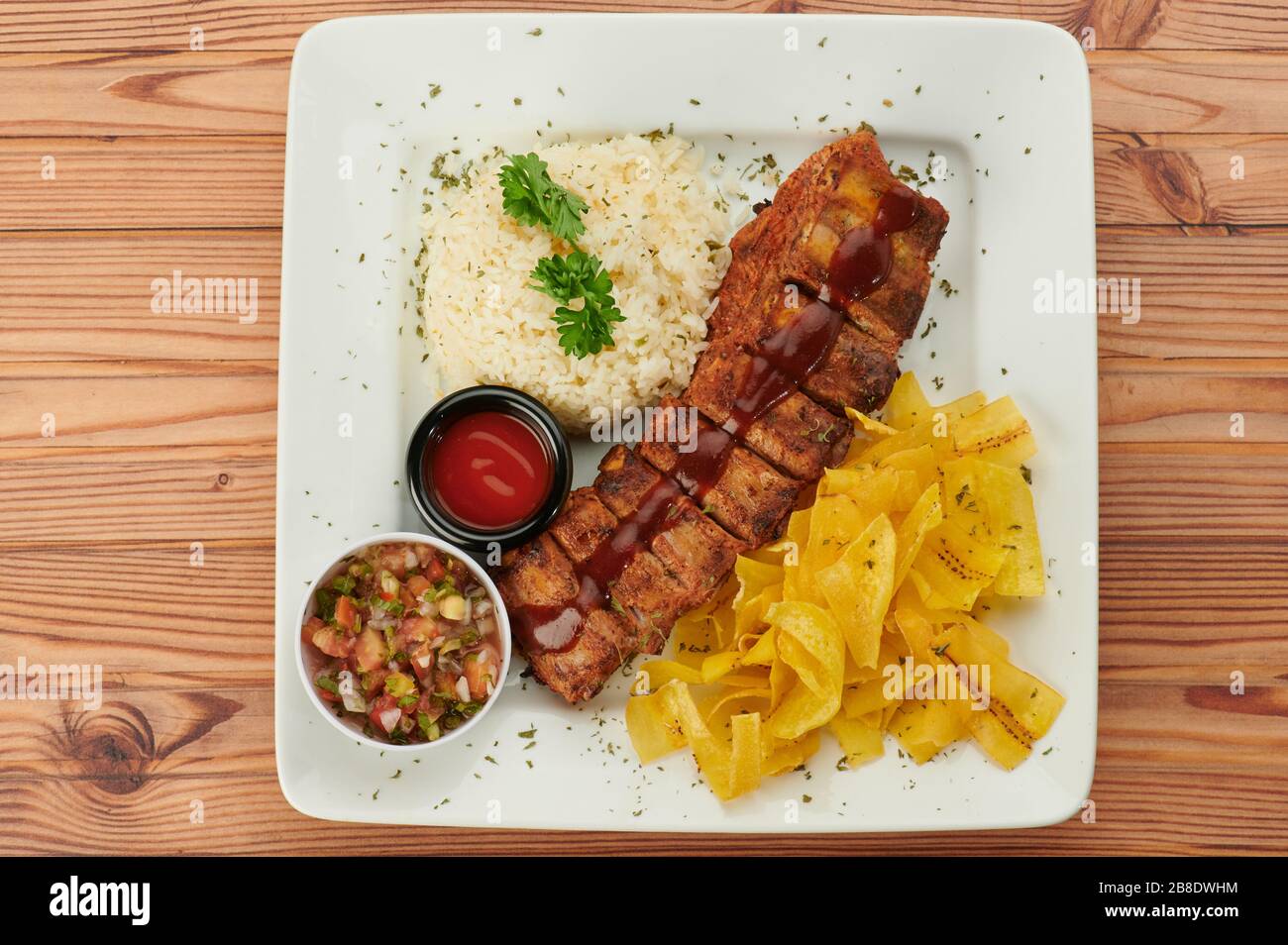 Grilled bbq ribs with salsa on wooden table above top view Stock Photo