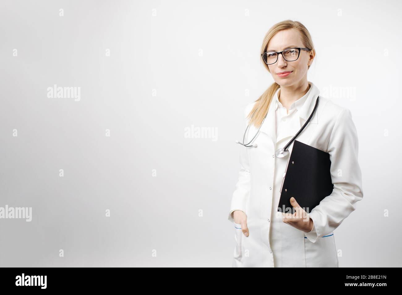 Confident medical worker holding clipboard at studio Stock Photo
