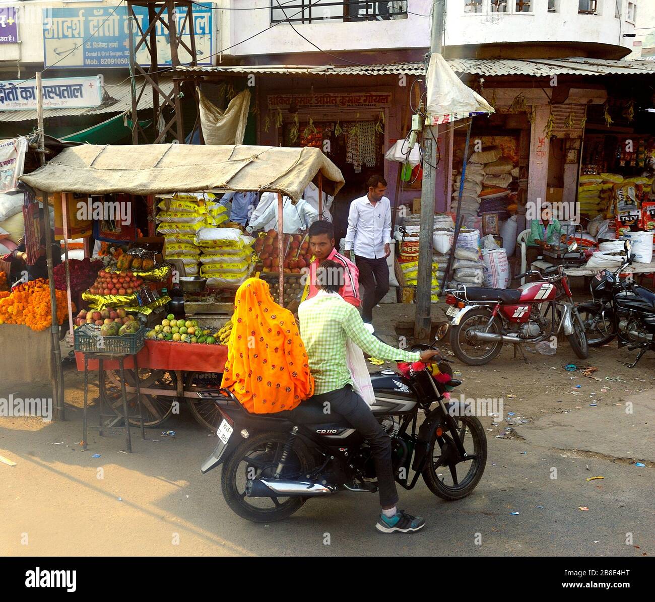 Ranthambhore, India - 10th November 2019:Family on a motorbike stopped at the fresh fruit stall Stock Photo