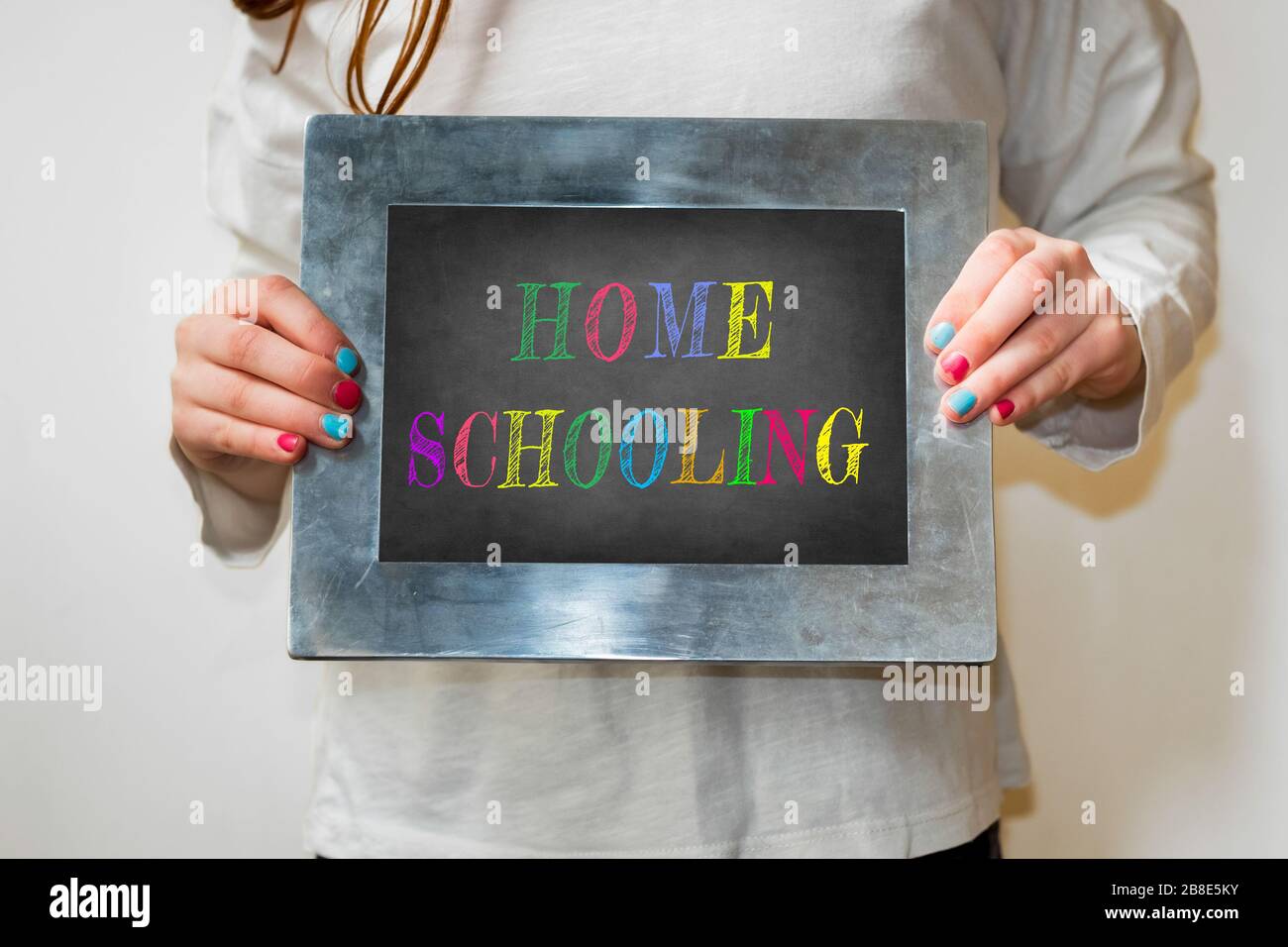 child holding up a blackboard with the word homeschooling Stock Photo