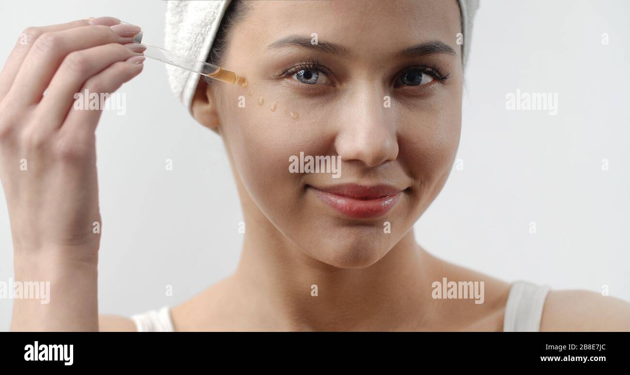 Young beauty applying facial oil Stock Photo Alamy