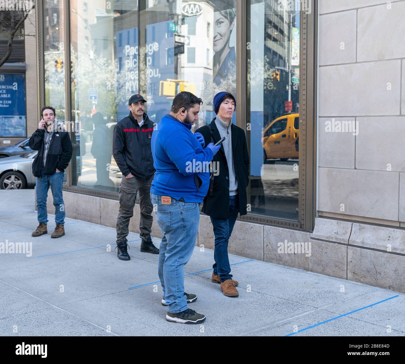 New York, NY - March 21, 2020: Worker takes order on the street from customers to maintain social distances of 6 feet at Best Buy electronic store on Broadway Stock Photo