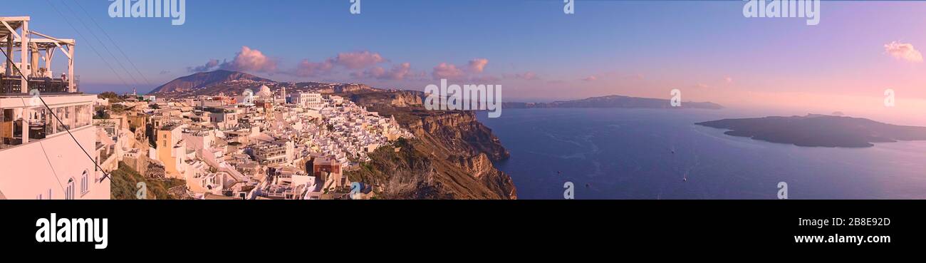 Panorama of Santorini island with Thira town on the cliff in the evening, Greece -- Greek panoramic landscape - cityscape Stock Photo