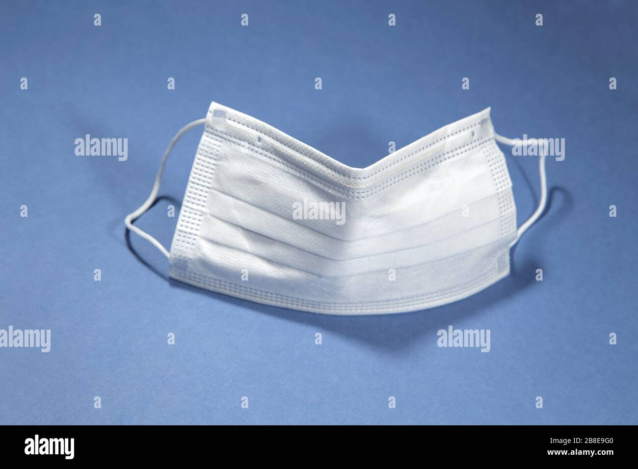 Protective face mask on blue background Stock Photo