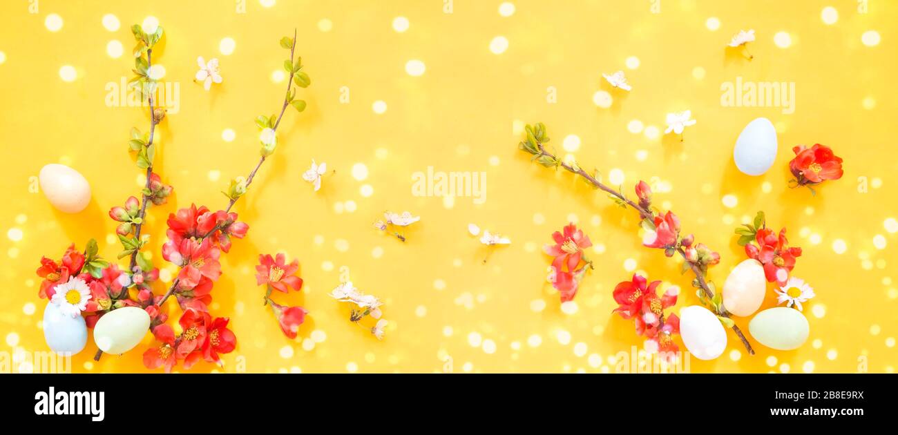 Easter eggs and flowers on yellow  background Stock Photo