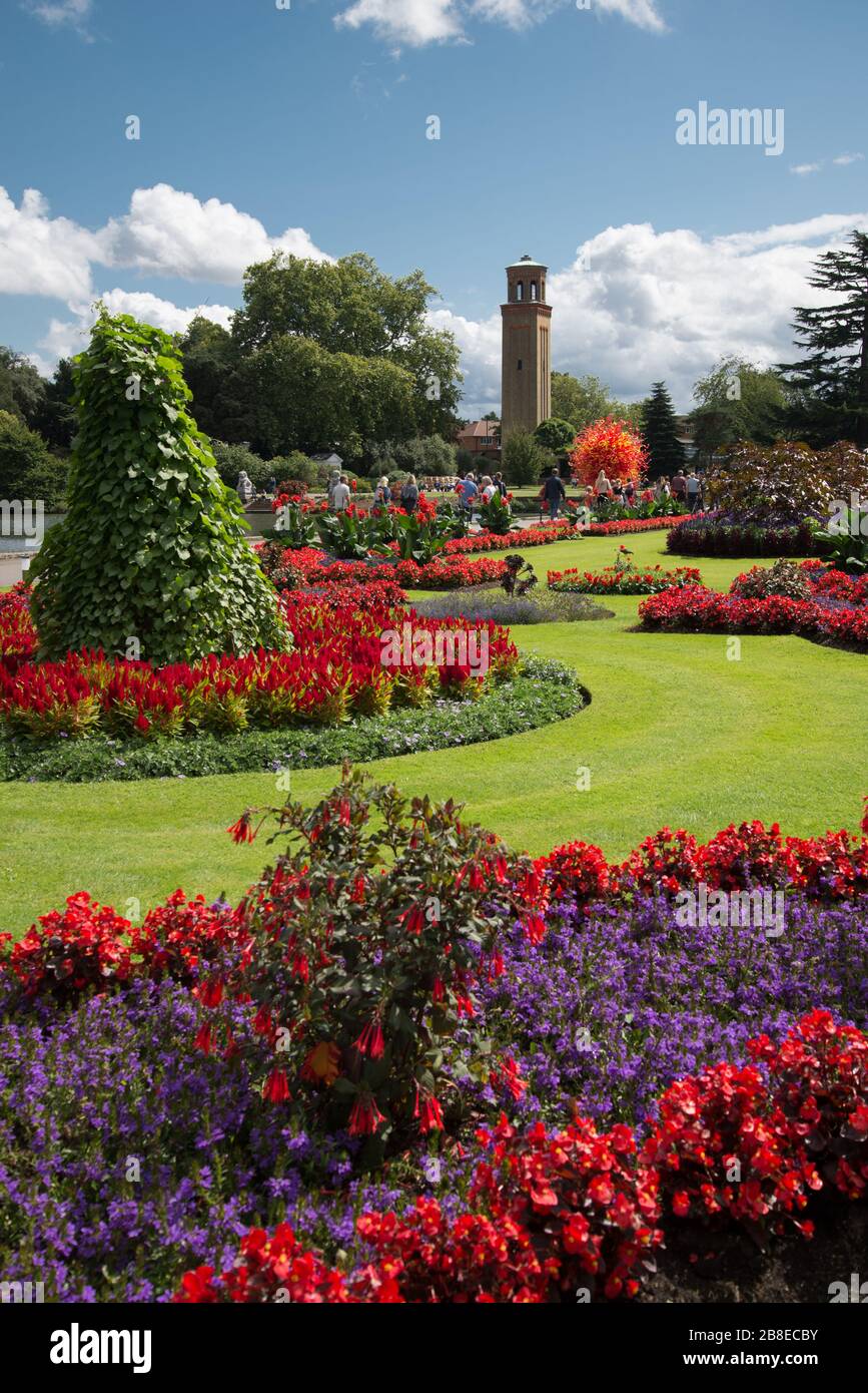 Formal Flower Garden in front of the Palm House in Kew Gardens, London & Dale Chihuly Summer Sun glass sculpture in front of the Campanile Stock Photo
