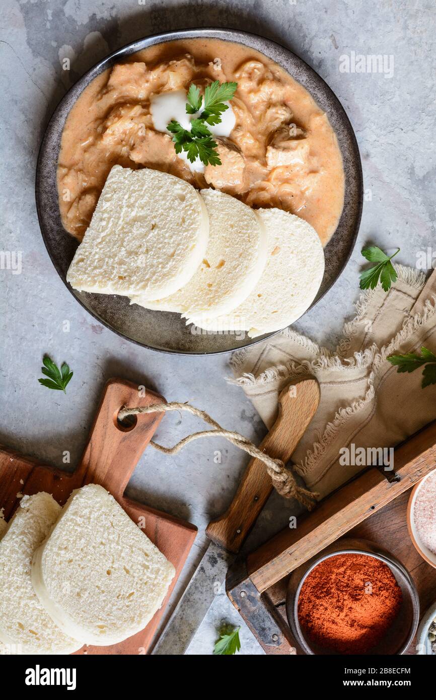 Classic Hungarian Szegedin pork goulash with dumplings on a ceramic