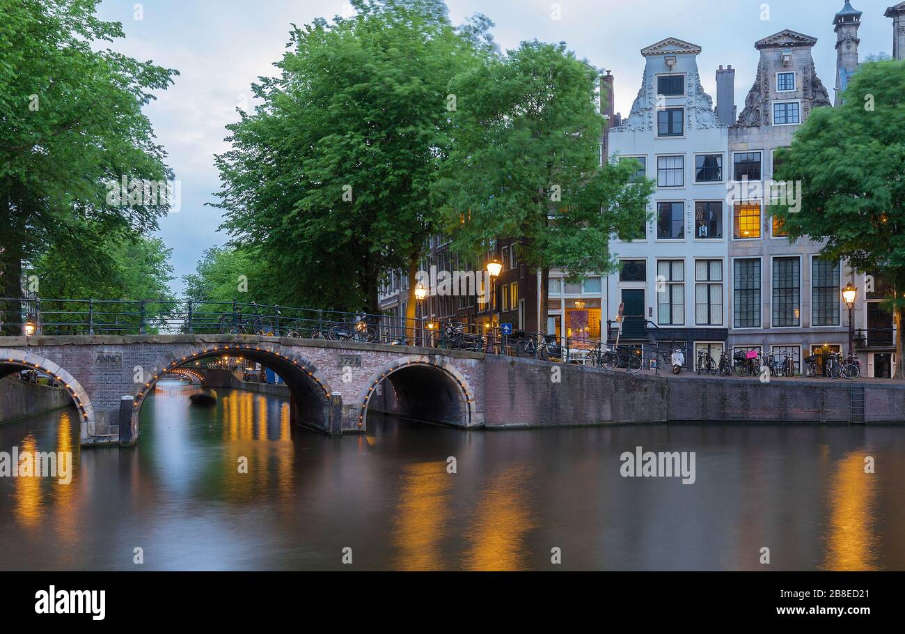Beautiful view of Amsterdam canals with bridge and typical dutch houses. Holland Stock Photo