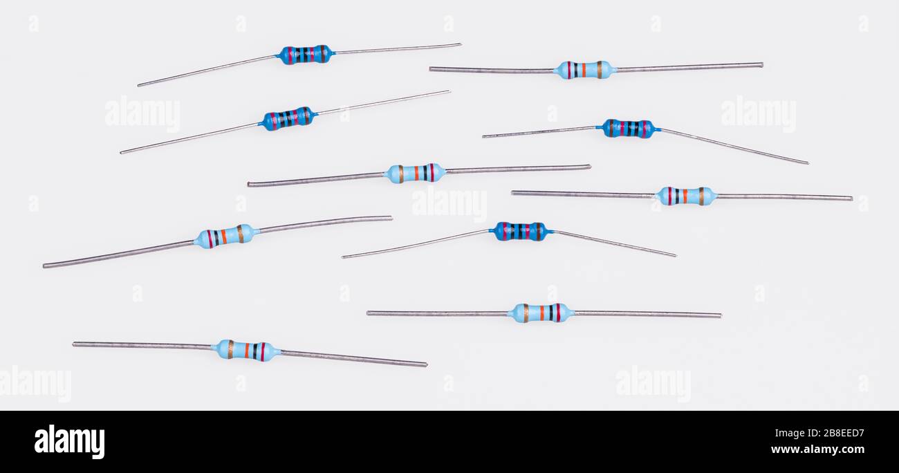 Set of blue miniature carbon resistors on white. Group of passive two terminal electrical components. Colorful bands of electronic standard color code. Stock Photo