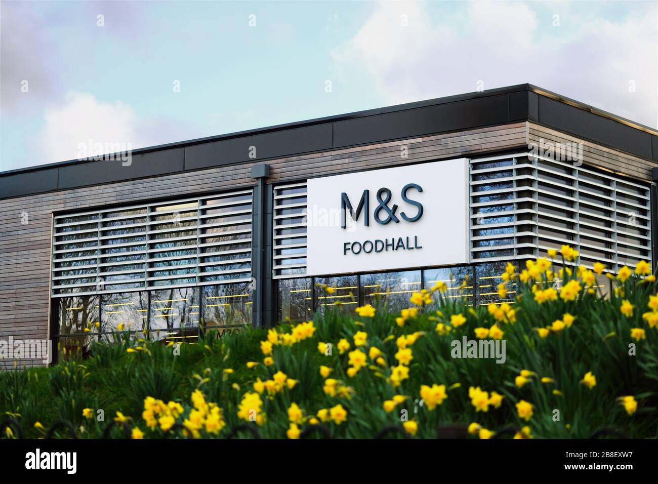 M&S Foodhall supermarket. Marks & Spencer shop front surrounded by flowers. Stock Photo