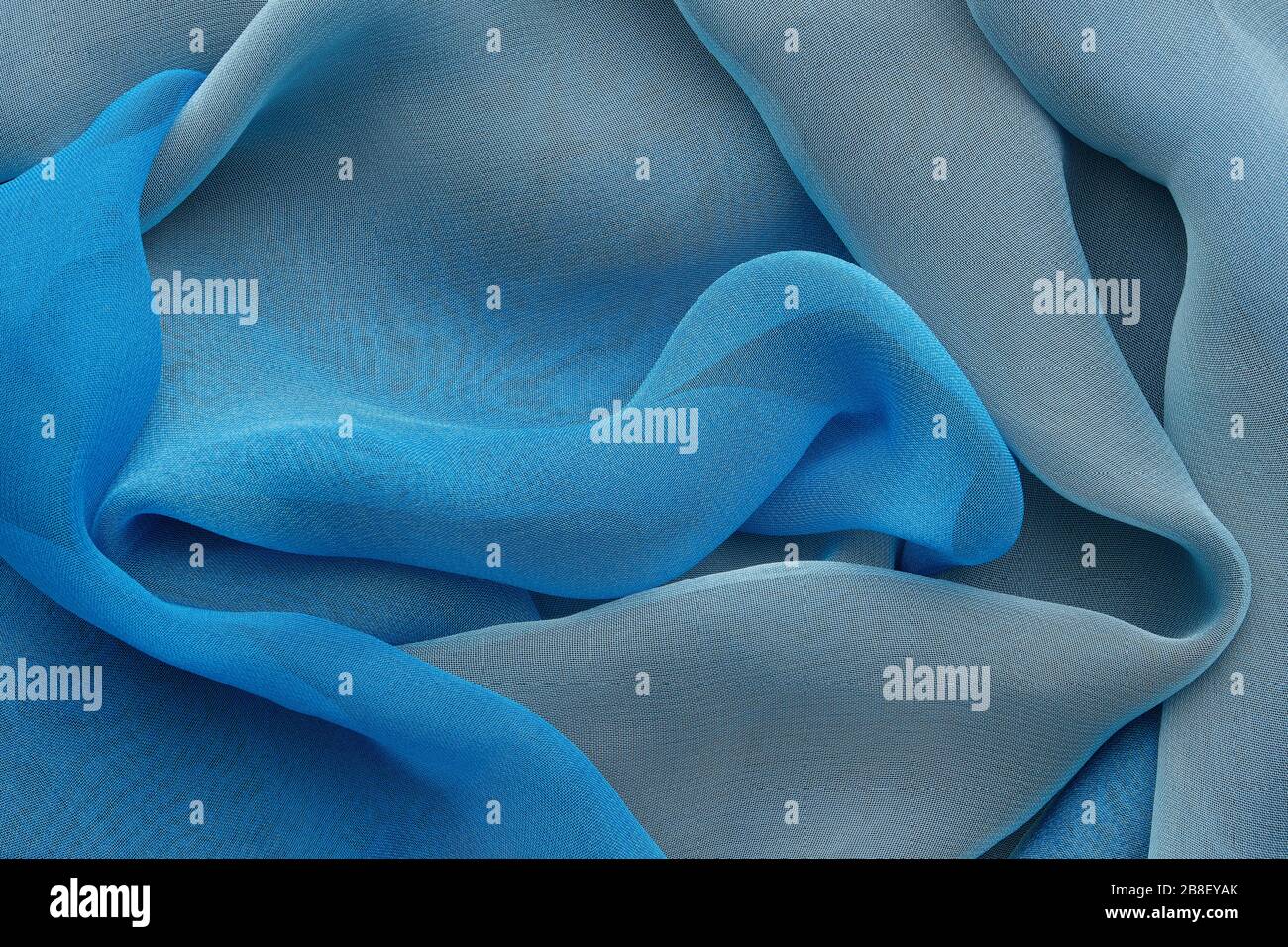 Blue draped silk fabric or scarf. Silk waves background. Stock Photo