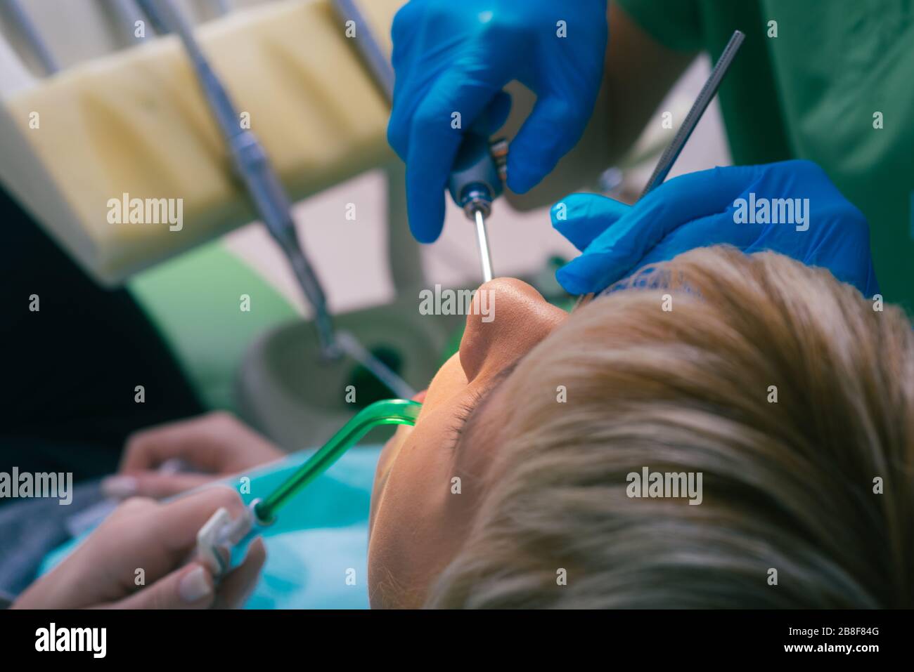 Female dentist with rubber gloves checking up the teeth of her patient