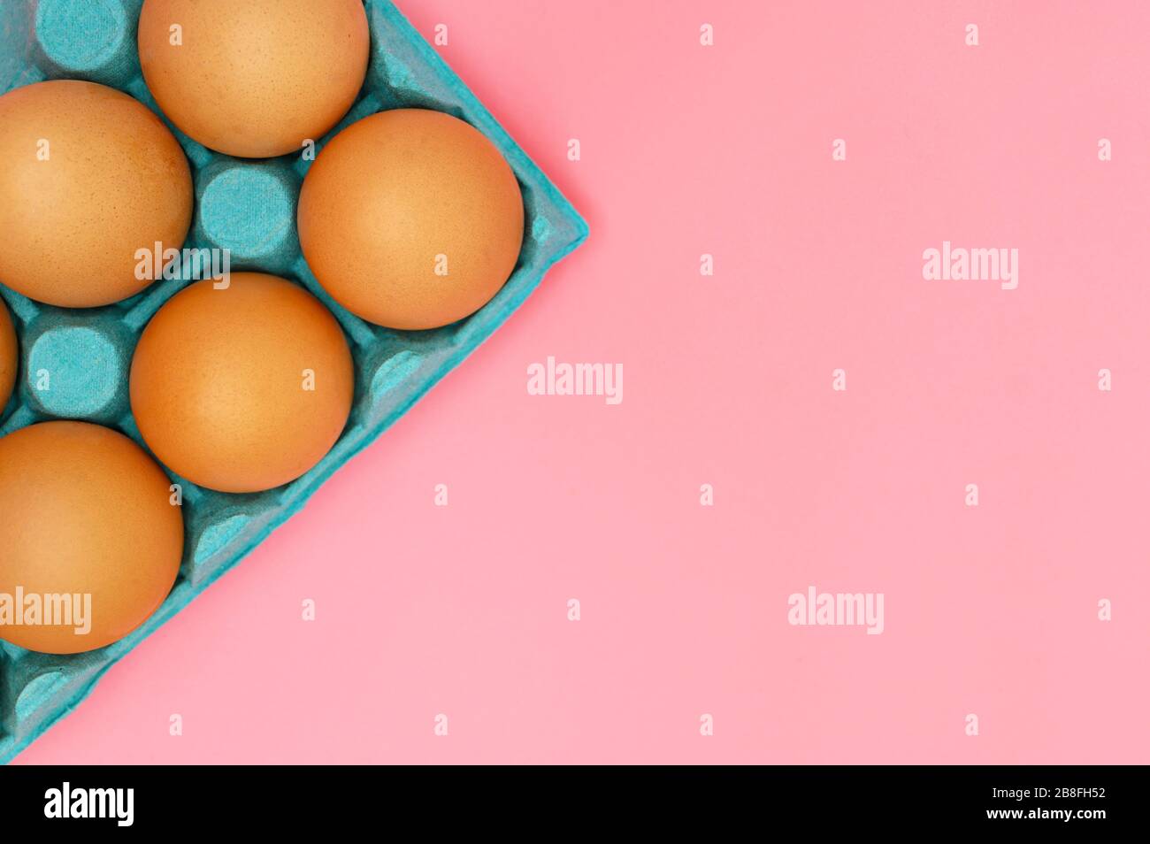 Raw brown chicken eggs on pink background . Stock Photo