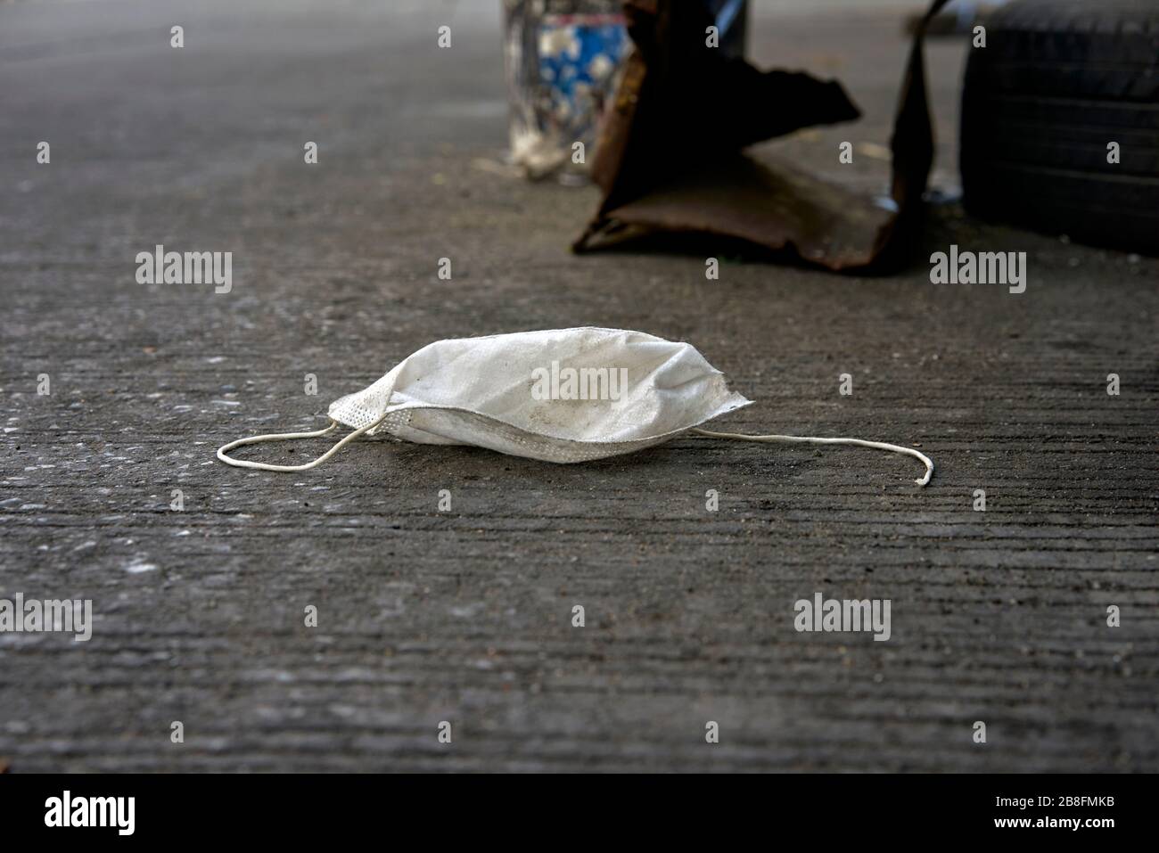 Covid-19 mask. Concept of the end in sight of Coronavirus 2020 pandemic with a discarded facemask on the street Stock Photo