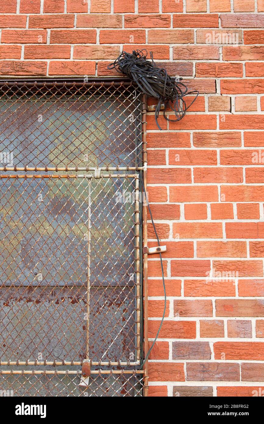 Bundle of wire on a steel mesh grate over a window Stock Photo