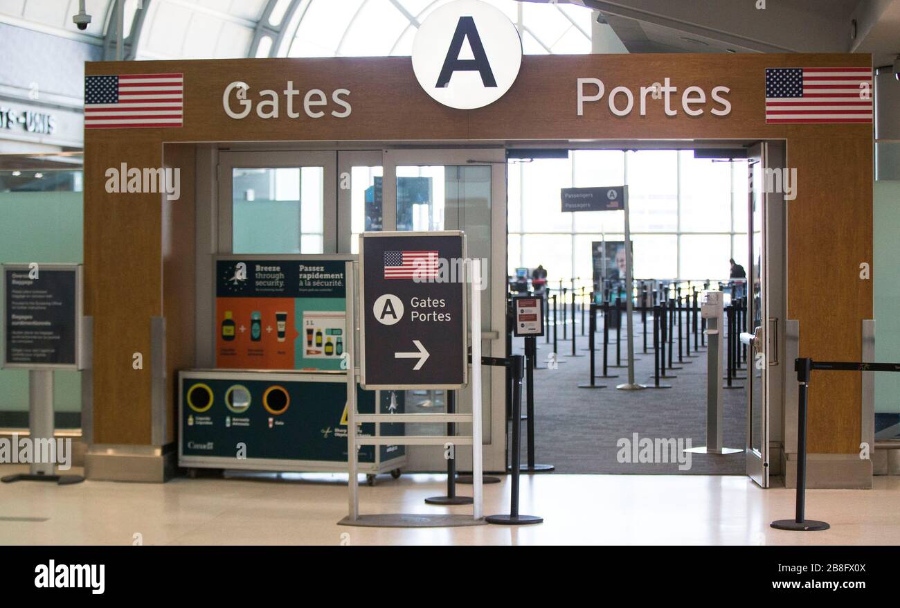 Ontario, Canada. 21st Mar, 2020. The security gates to the U.S. are seen with few people at the Terminal 3 of the Pearson International Airport in Toronto, Canada, March 21, 2020. At midnight on Friday the land border between Canada and the United States was closed to all non-essential travel in an effort to stem the spread of COVID-19. Credit: Zou Zheng/Xinhua/Alamy Live News Stock Photo