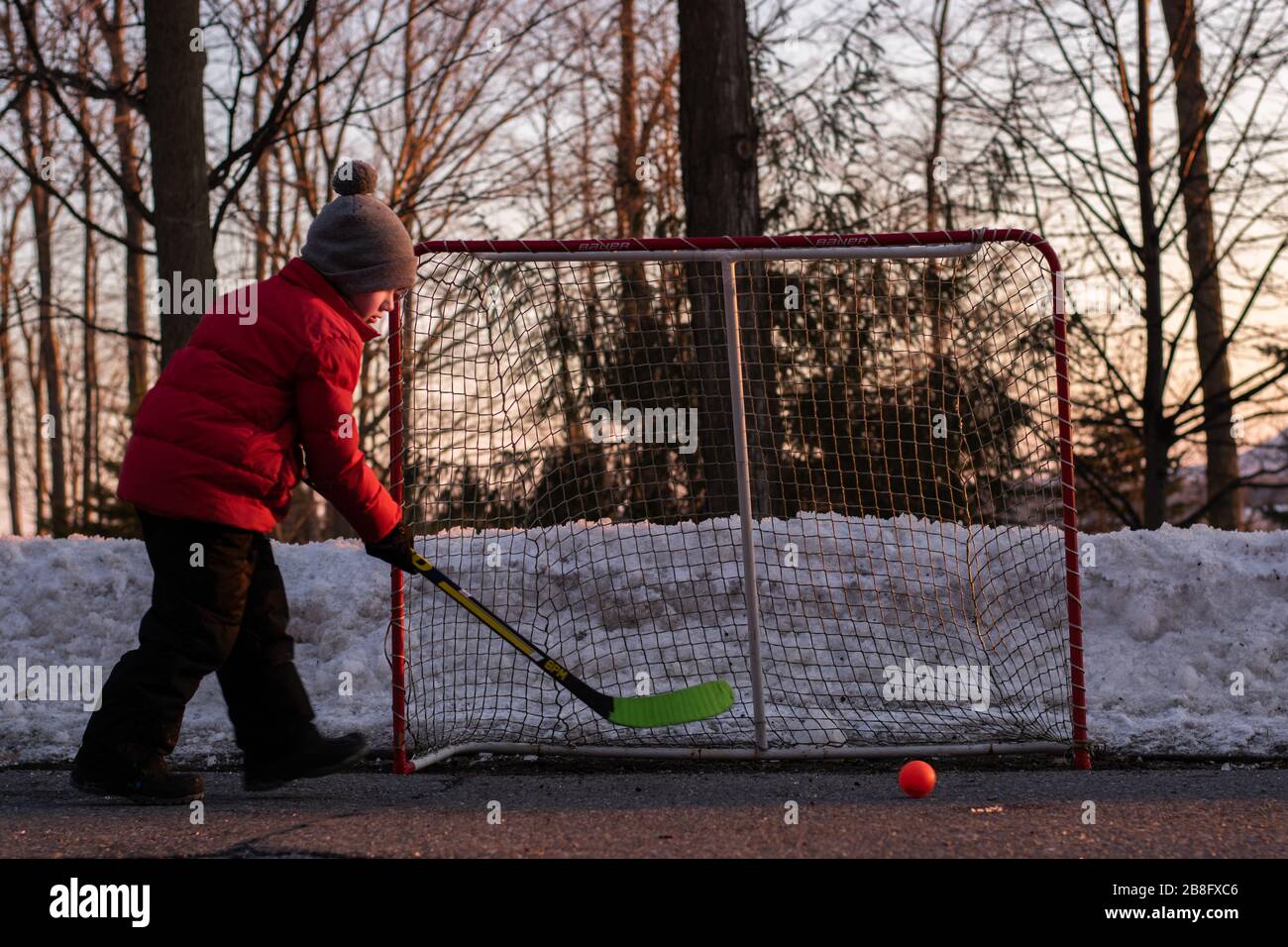 A boy playing outdoor hockey in winter Stock Photo