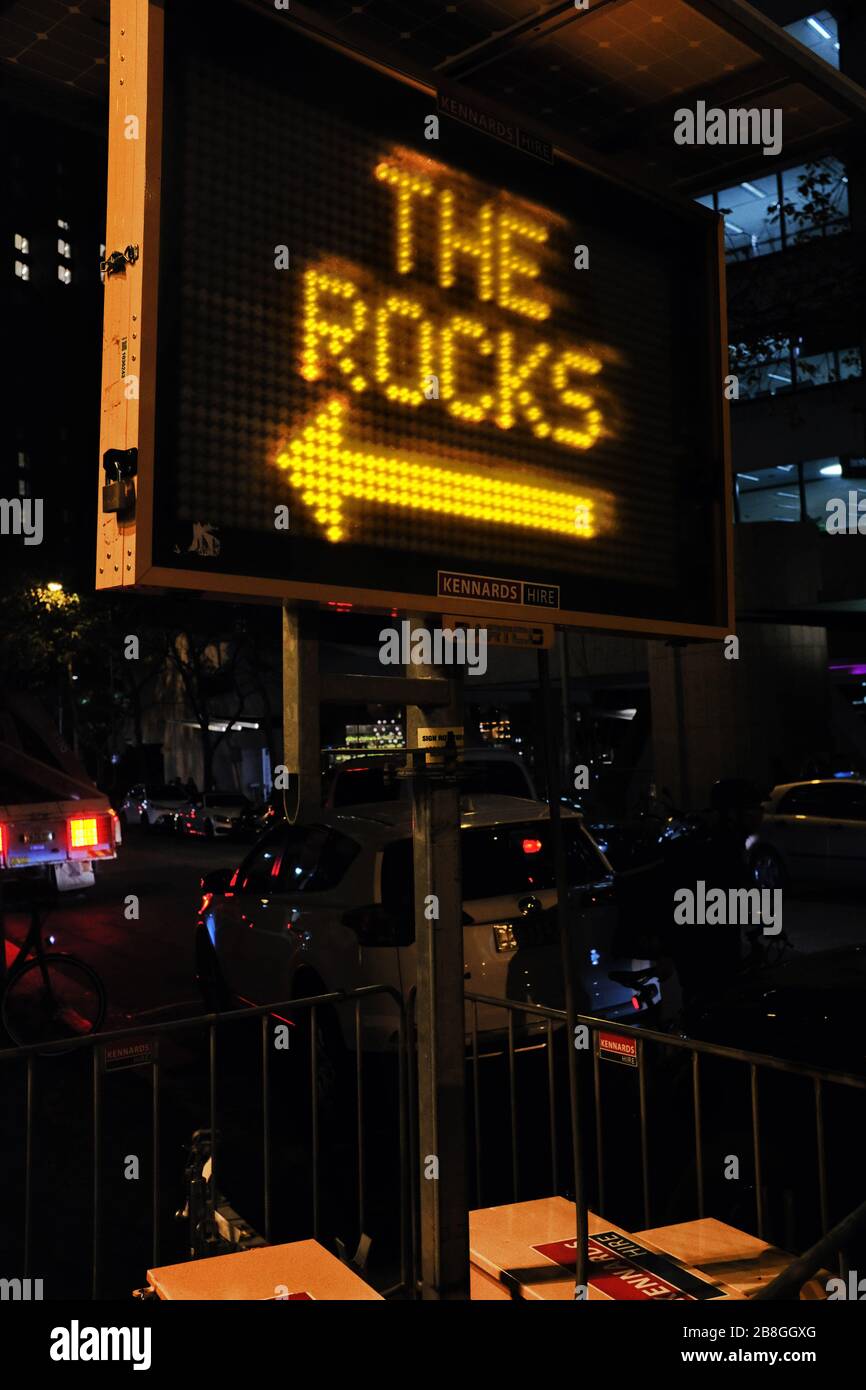 Illuminated sign pointing the way to THE ROCKS - VIVID Sydney, the popular annual event of light sculptures and creative illuminated art Stock Photo