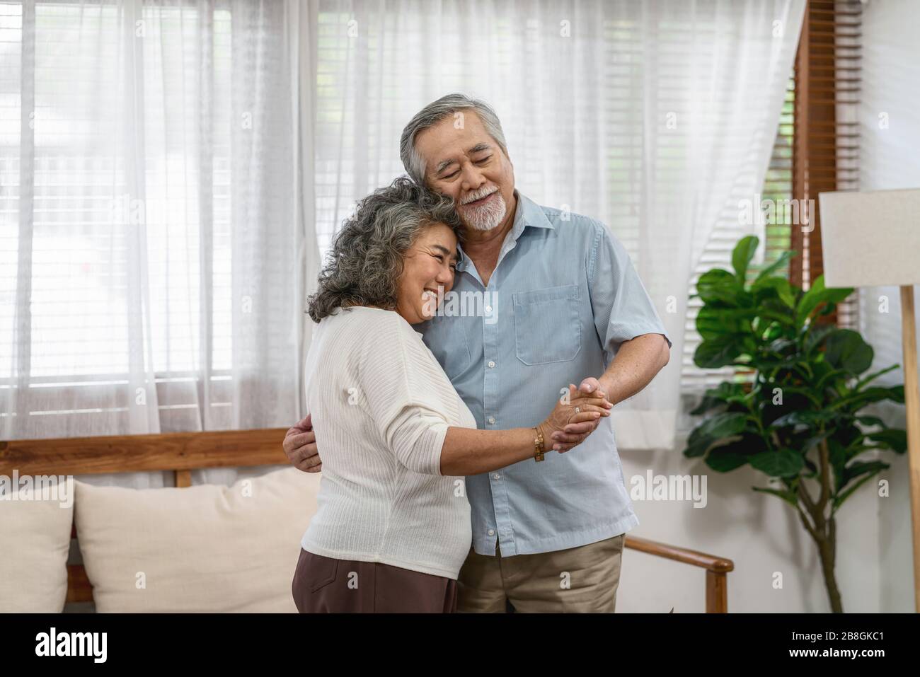Asian couple Grandparent dancing and hugging together with happy feeling in house, romantic and lover with valentine or anniversary, Long live and Eld Stock Photo