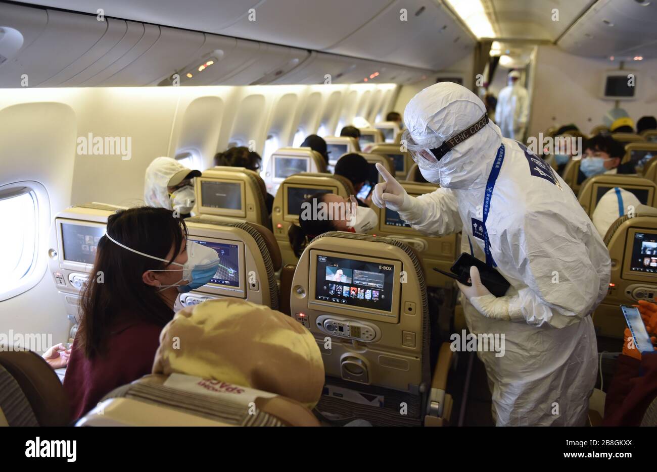 Beijing, China. 18th Mar, 2020. A customs officer answers questions for inbound passengers on a flight at the Capital International Airport in Beijing, capital of China, March 18, 2020. Credit: Chen Zhonghao/Xinhua/Alamy Live News Stock Photo