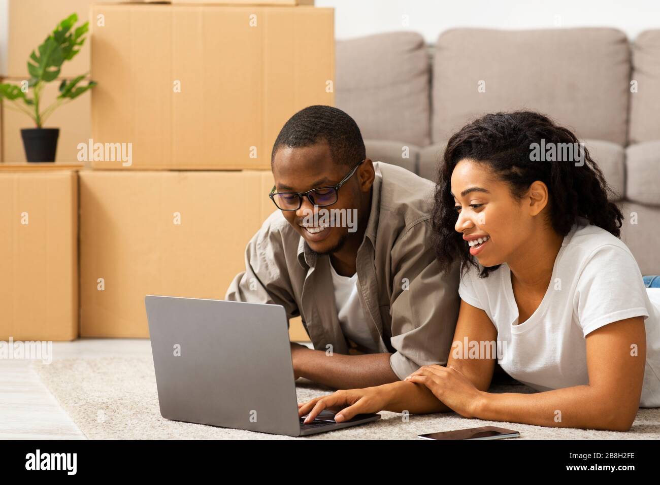 Couple deciding how to design their home with laptop Stock Photo