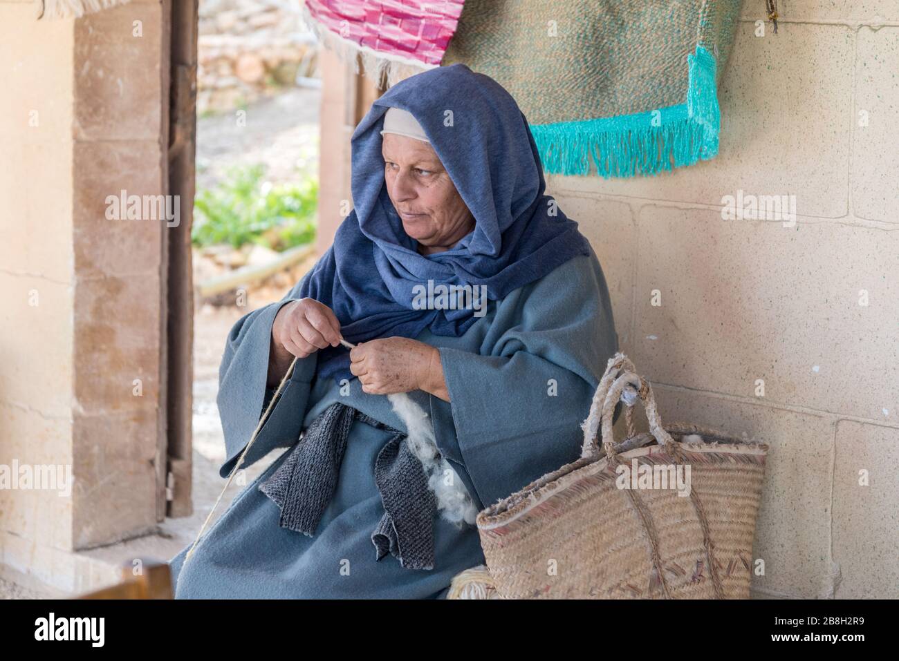 An elderly woman working on wool with her hands in the village of Ghajnsielem in Gozo, Malta Stock Photo