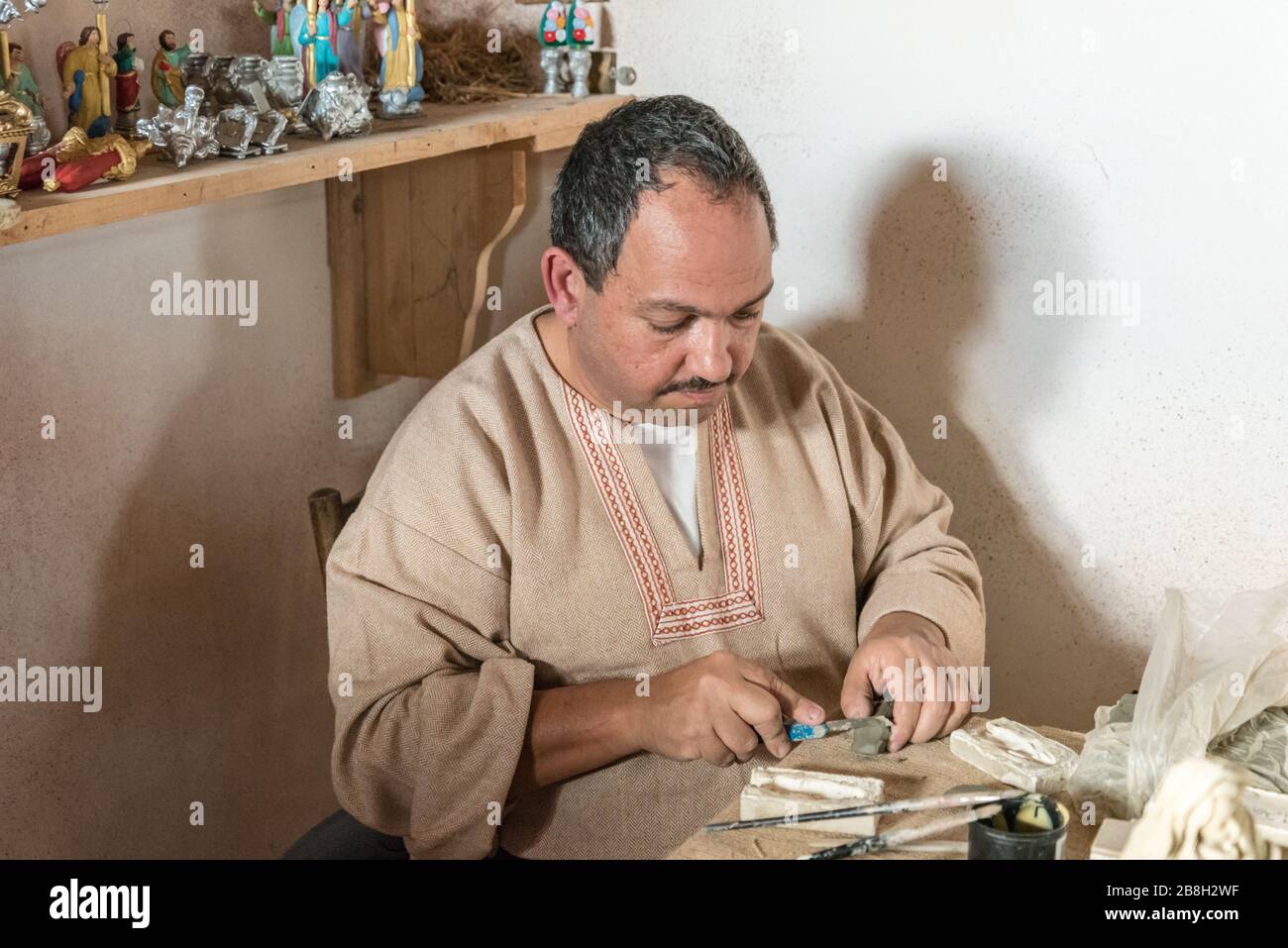 A man working creating clay statues with his hands in the village of Ghajnsielem in Gozo, Malta Stock Photo