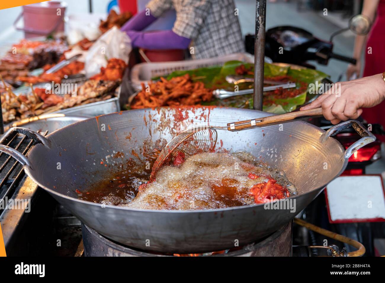 Street food in Thailand. deep-fried chicken using a large frying pan with boiling oil. Food from carts, travel and local flavor. Stock Photo