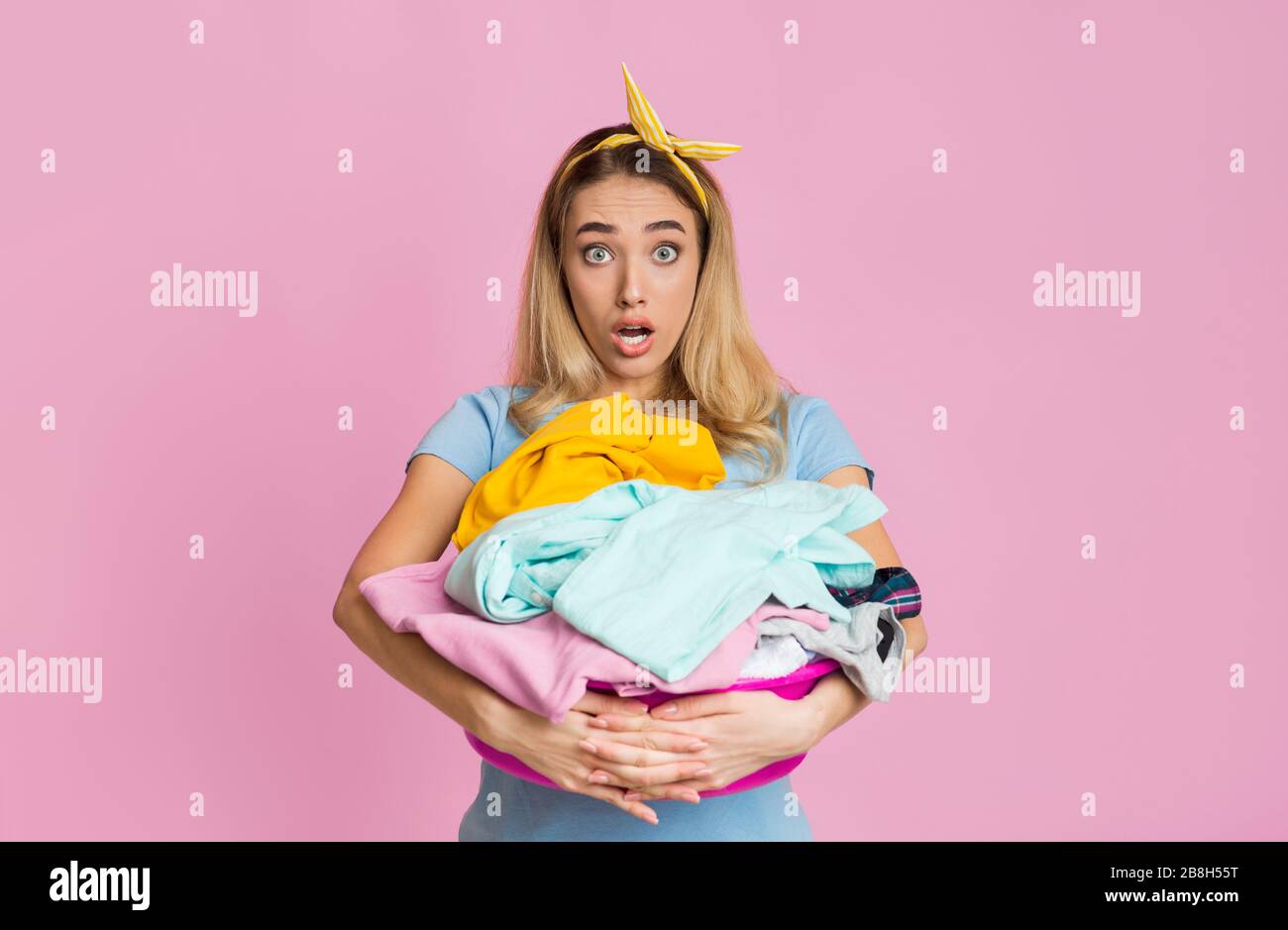 Housewife with basin of dirty clothes in her hands Stock Photo