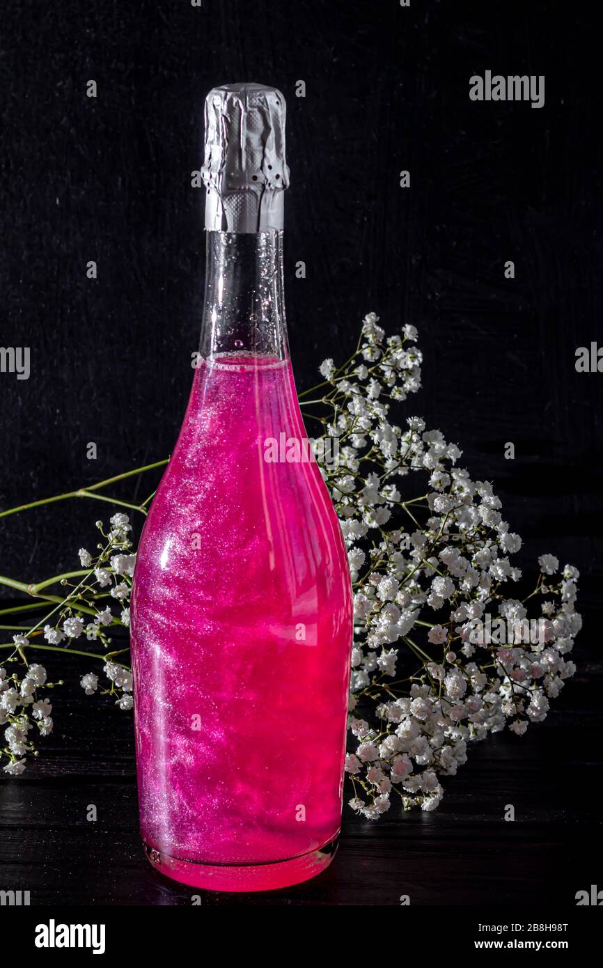 Sparkling brilliant raspberry drink. Champagne in two glasses stands on ...
