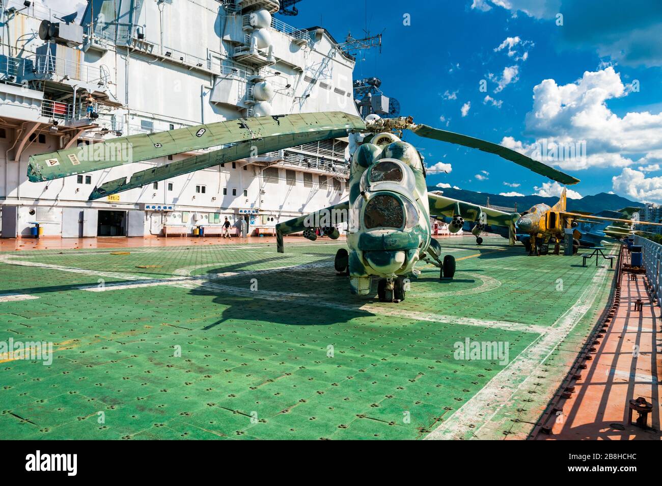 Mil attack helicopter Hind on the flight deck of the Minsk aircraft carrier in Shenzhen. MiG-23 in background. Stock Photo
