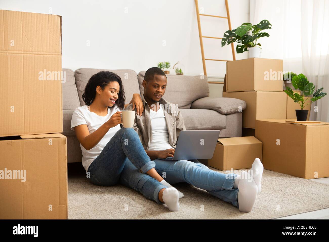 African american couple sitting on the floor looking at laptop Stock ...