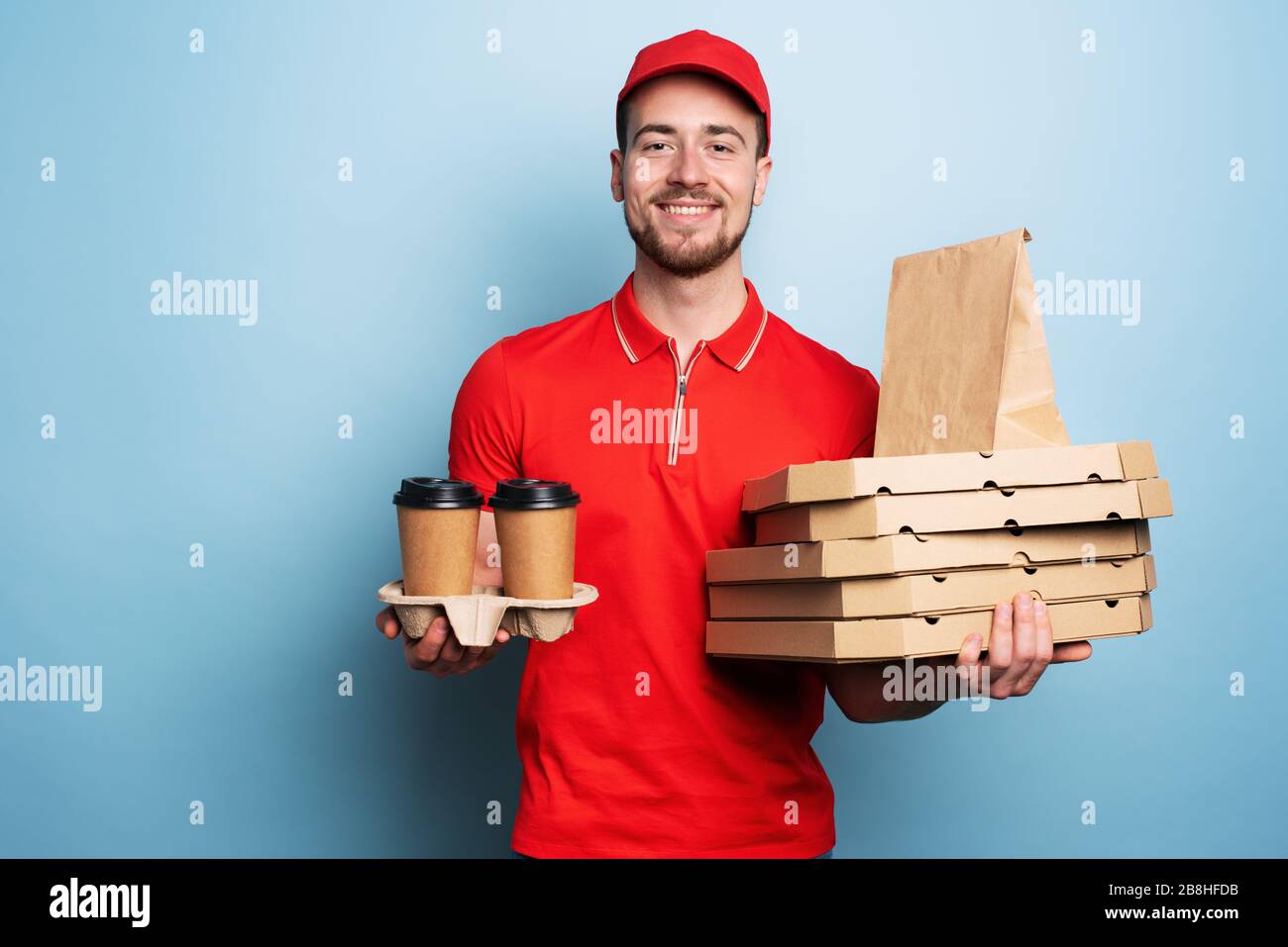 Courier is happy to deliver hot coffee and pizzas. Cyan background Stock Photo