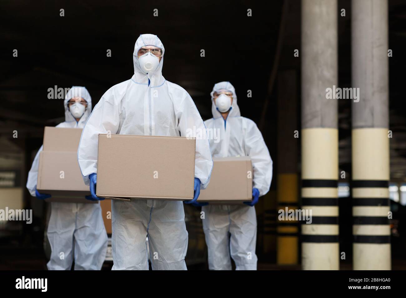 People in protective suits and masks delivering vaccine Stock Photo