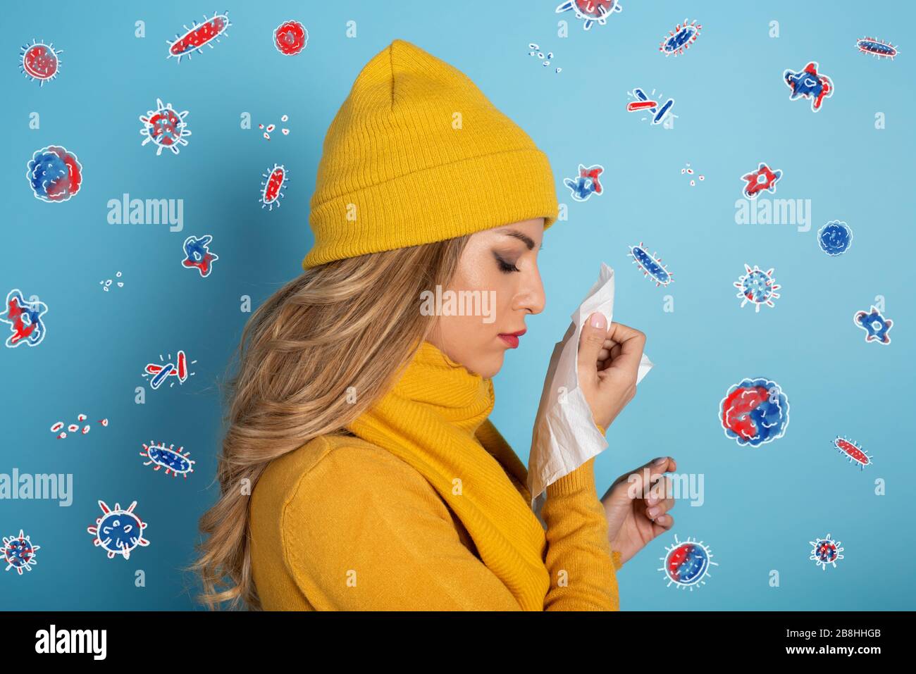 Girl caught a cold and is surrounded by viruses and bacteria. Studio on Cyan background Stock Photo
