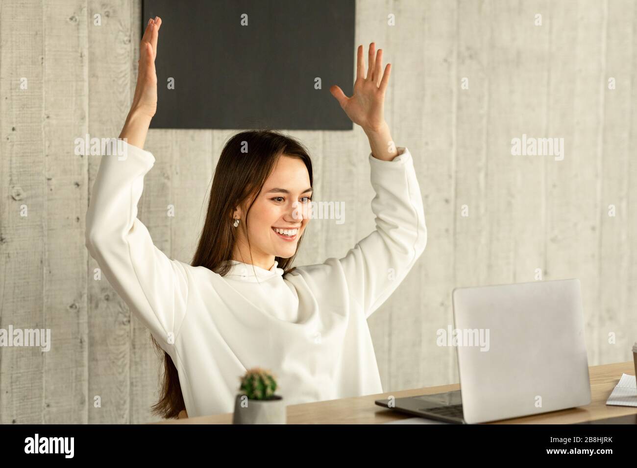 Lucky at work. Woman raised her hands up Stock Photo
