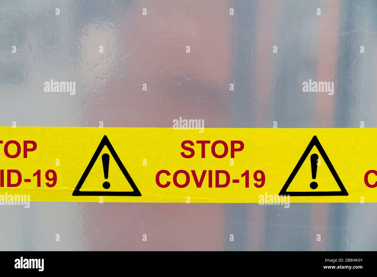 Danger Covid-19 warning tapes red on a yellow background Stock Photo