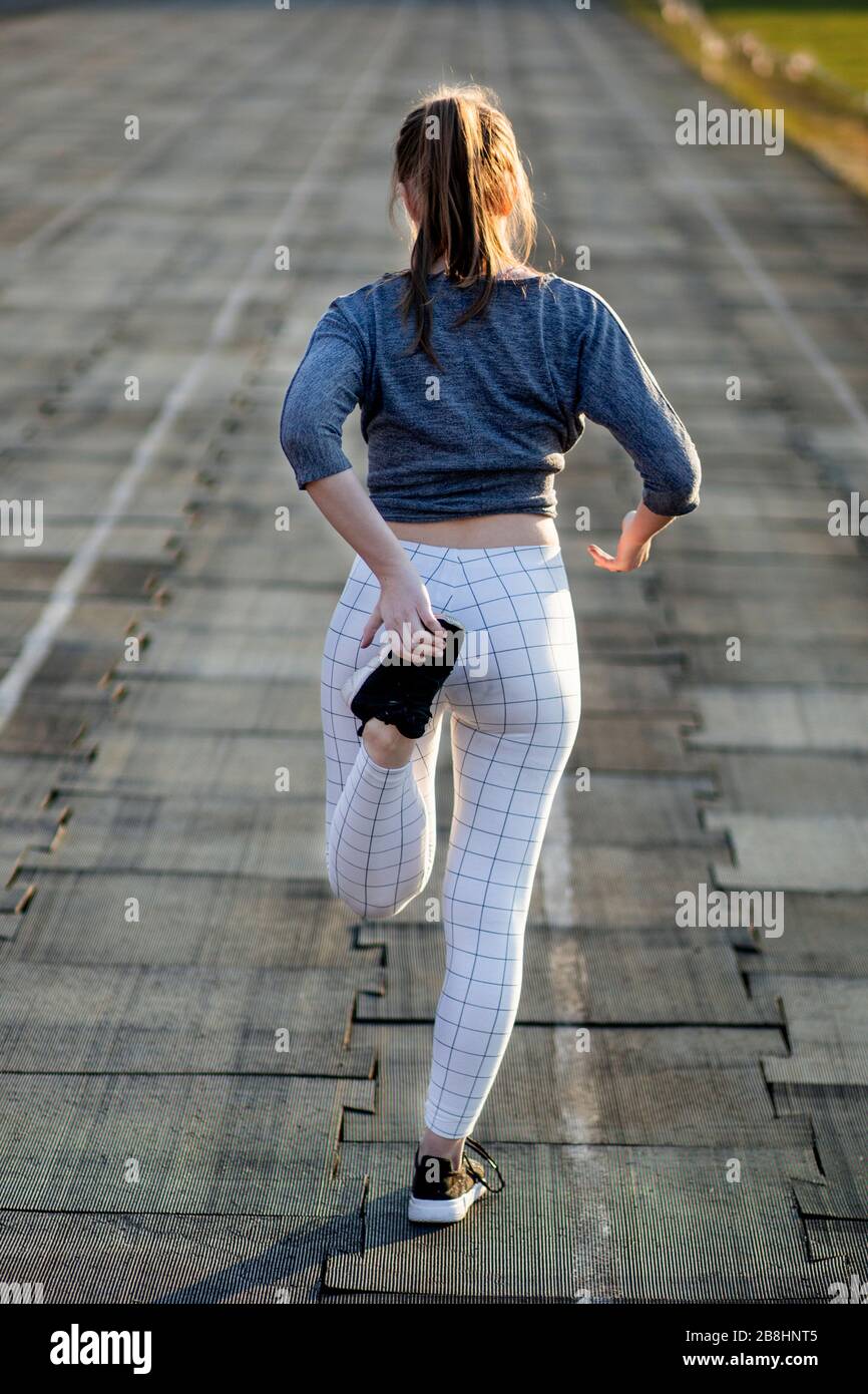 Female runner stretching legs on running track Stock Photo Alamy