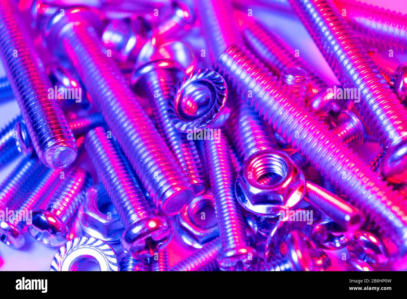 Metal bolts and nuts in a row background. Chromed screw bolts and nuts