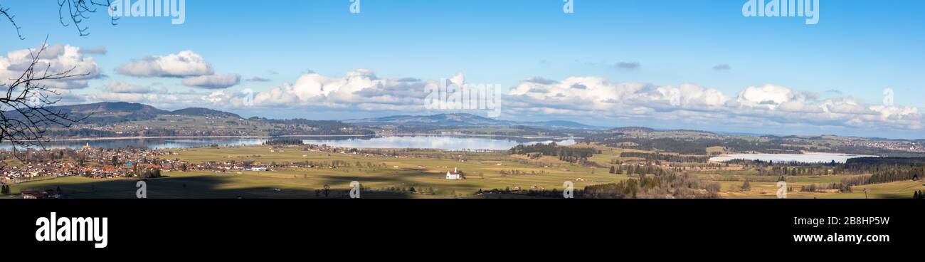 Panorama view of the landscape with Forggensee lake and Bannwaldlake from Neuschwanstein Castle on a sunny winter day with blue sky cloud in backgroun Stock Photo