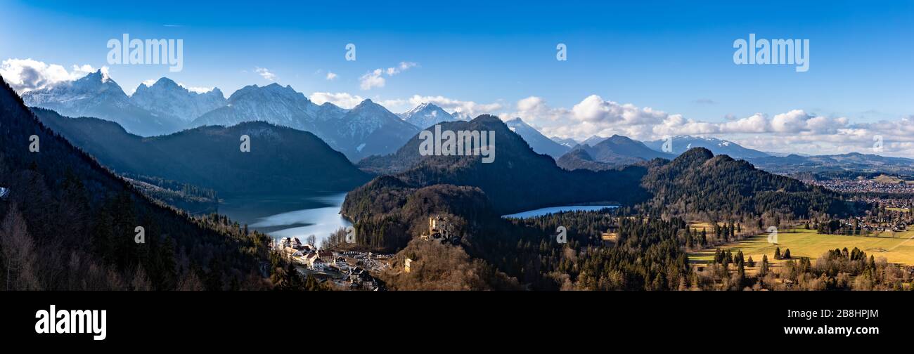 Panorama view of the Bavarian Alps and Lake with the famous Hohenschwangau Castle and Alpsee lake, Schwansee lake on a sunny day in winter, Schwangau, Stock Photo