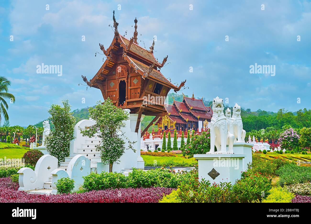 The stilt wooden mondop (pavilion) of Buddhist shrine with carved pyathat roof, surrounded by white Singha lions, located at the Roayal Pavilion of Ra Stock Photo