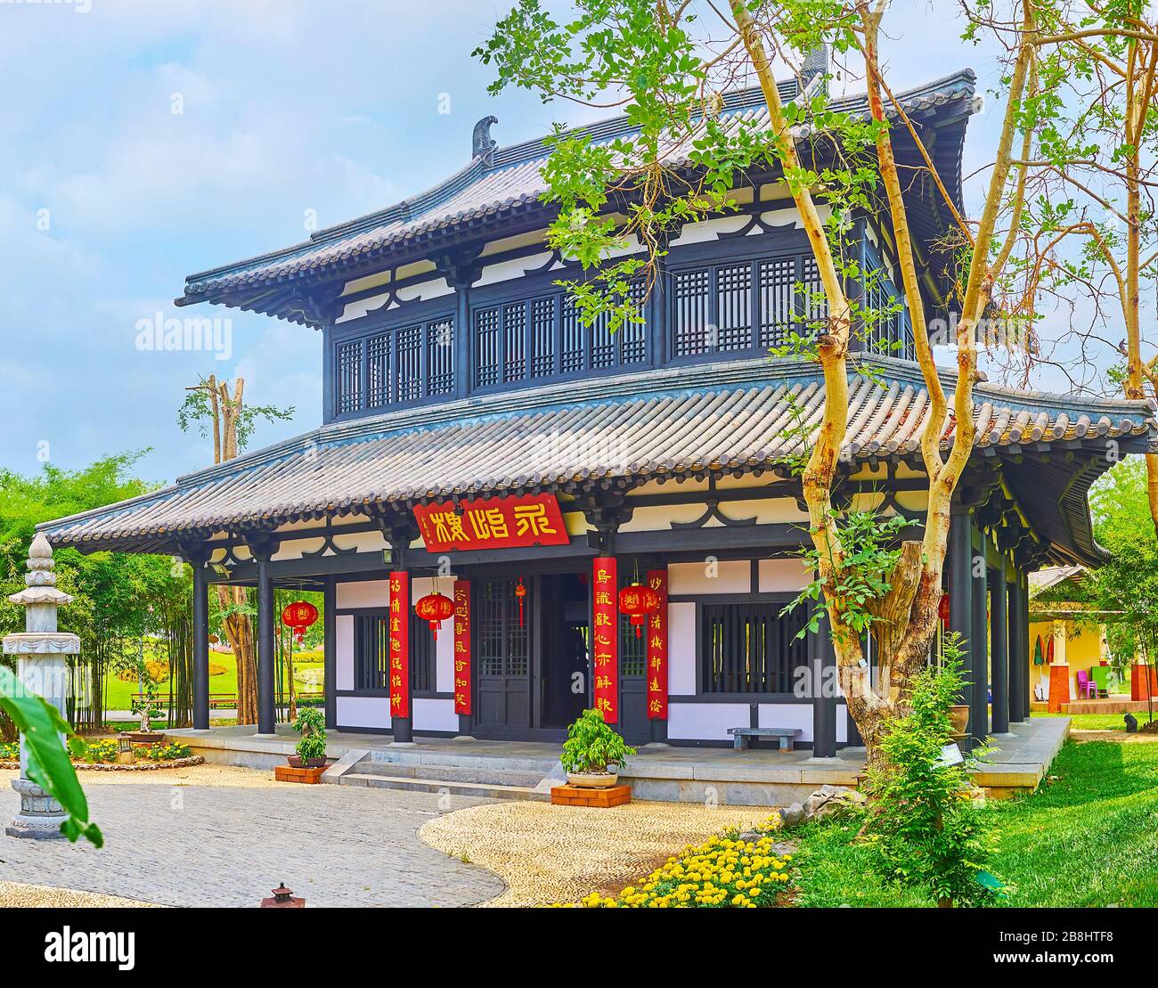 CHIANG MAI, THAILAND - MAY 7, 2019: The facade of black-white wooden pavilion of China garden with multi-tired tile roof, many windows and lanterns, R Stock Photo