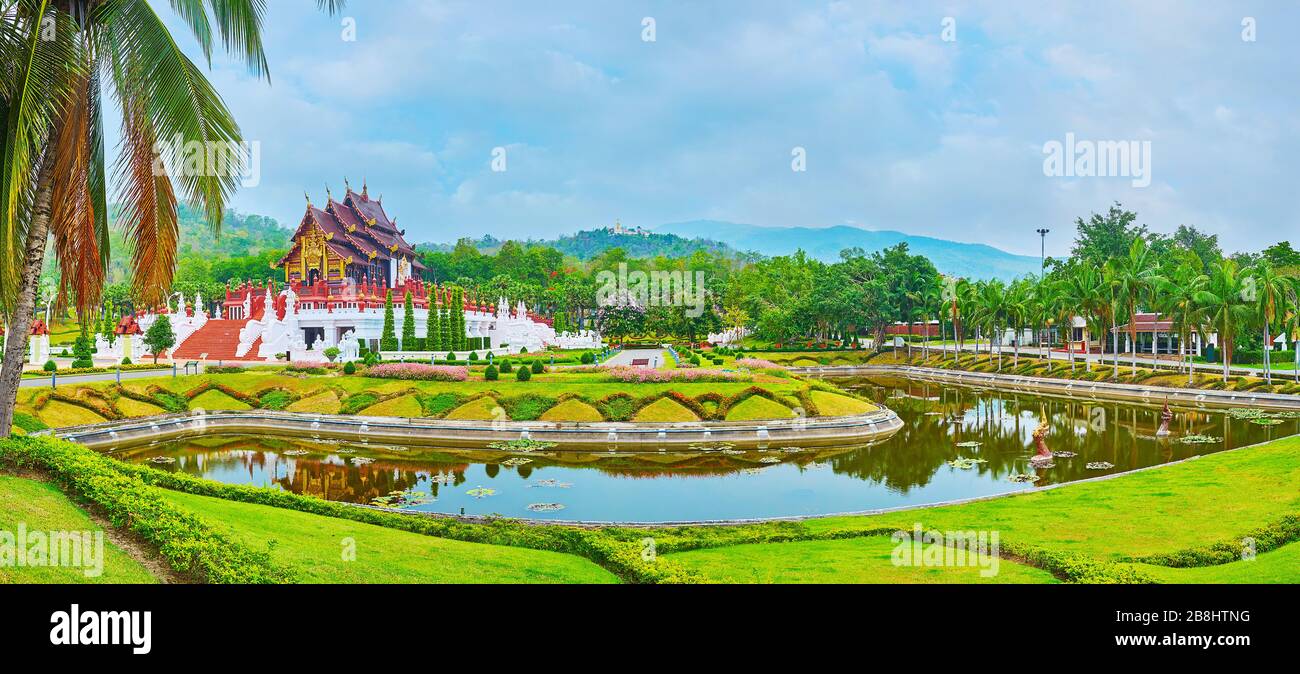 Panorama of Rajapruek park with Lanna style building of Royal pavilion, ornamental flower beds, green lawn and a pond, Chiang Mai, Thailand Stock Photo
